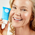 woman smiling holding Liquid Mineral Foundation
