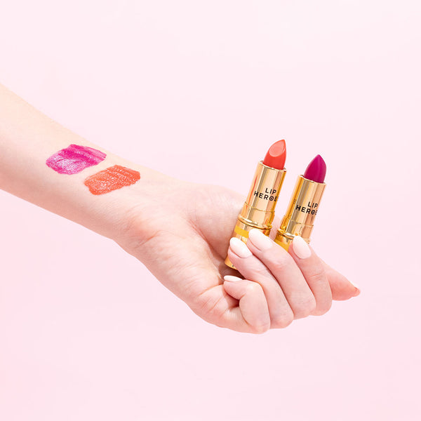 hand holding two lip heroes lipsticks